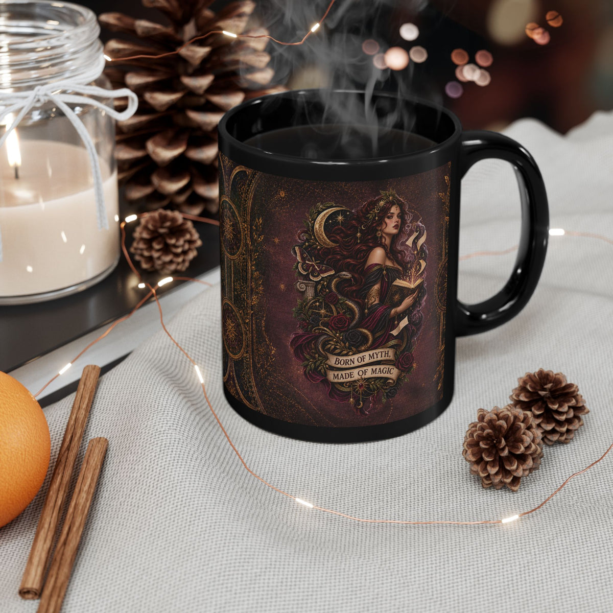 Black mug with decorative design on a table with candles, oranges, and pinecones.