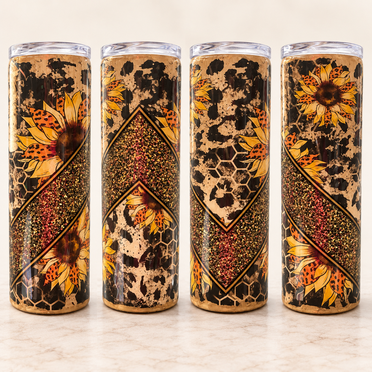 Four tall insulated tumblers with clear lids are lined up on a light marble surface. The tumblers feature a decorative wrap-around pattern combining black leopard spots, honeycomb textures, red speckled diagonal bands, and large yellow sunflower illustrations.
