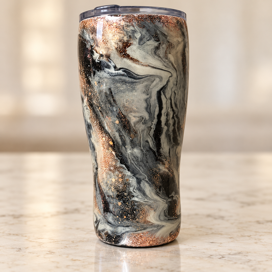 20 oz curved epoxy tumbler with black, smoky gray and cream marble swirls, warm metallic glitter accents and a glossy finish.