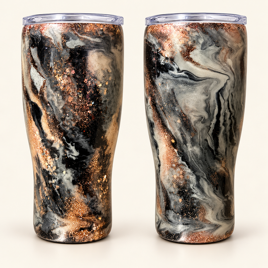 Two views of a handmade 20 oz curved marbled tumbler showing black, gray and cream swirls with warm metallic glitter accents.