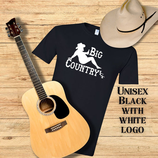 Black t-shirt with white 'Big Country ICT' logo, acoustic guitar, and cowboy hat on a wooden surface.